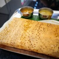 Traditional South Indian meal with folded dosa on a banana leaf tray, Indian restaurant Amsterdam