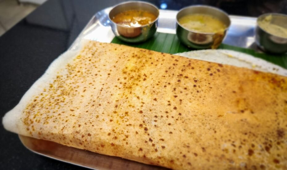 Traditional South Indian meal with folded dosa on a banana leaf tray, Indian restaurant Amsterdam
